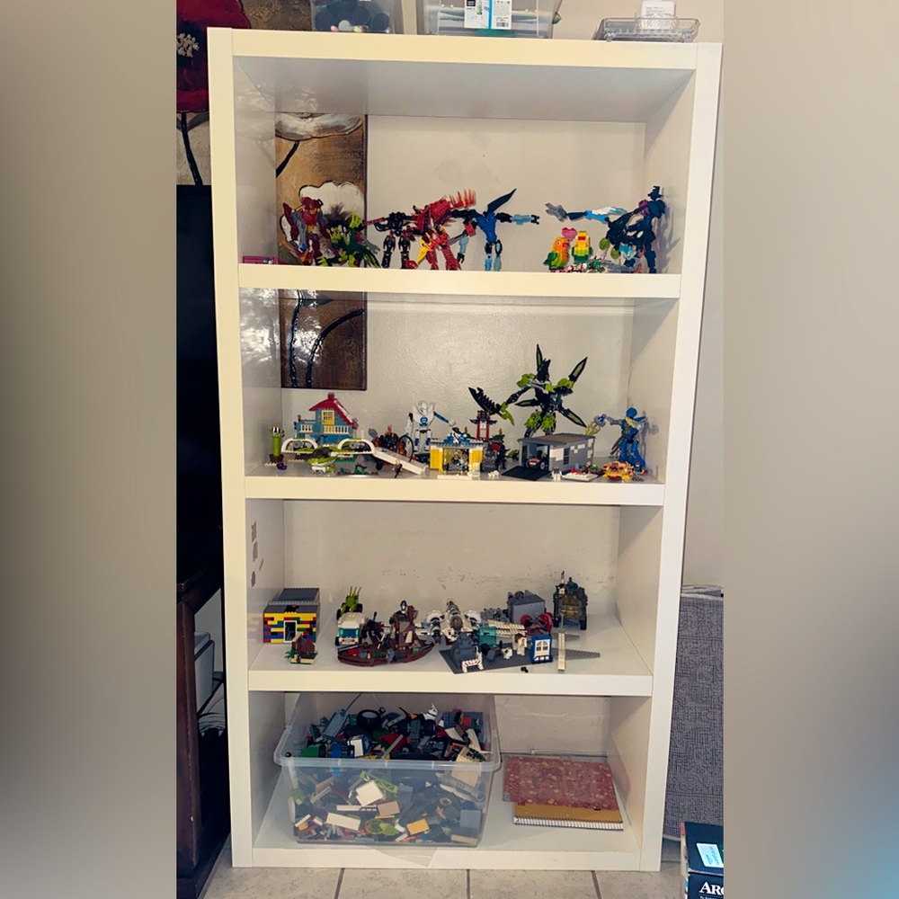 Beautiful white shelf with lots of built legos!